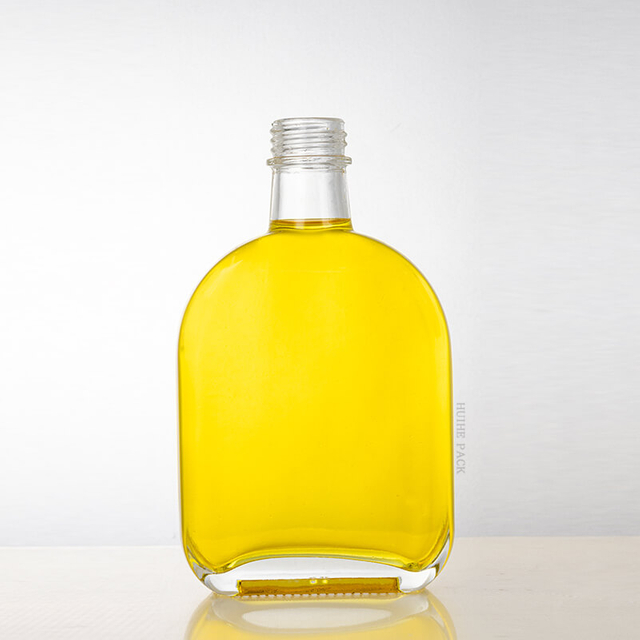 Bouteille d'alcool en verre transparent ovale avec bouchon à vis